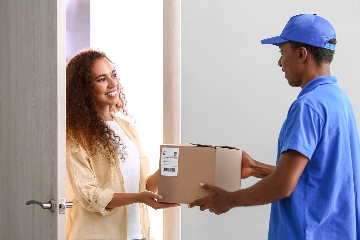 African-American Woman Receiving Parcel from Courier of Delivery Company