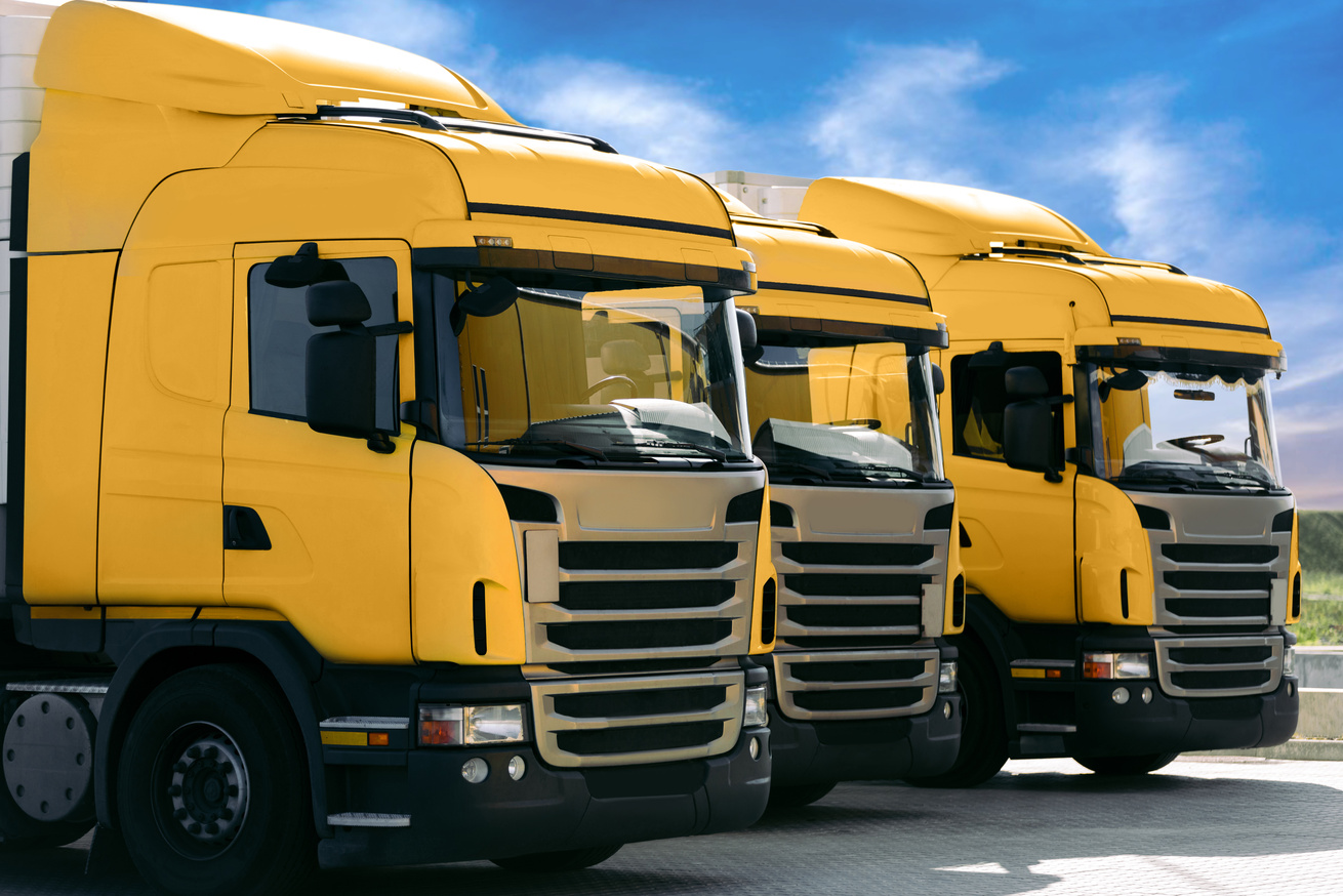 three yellow trucks of a transporting company